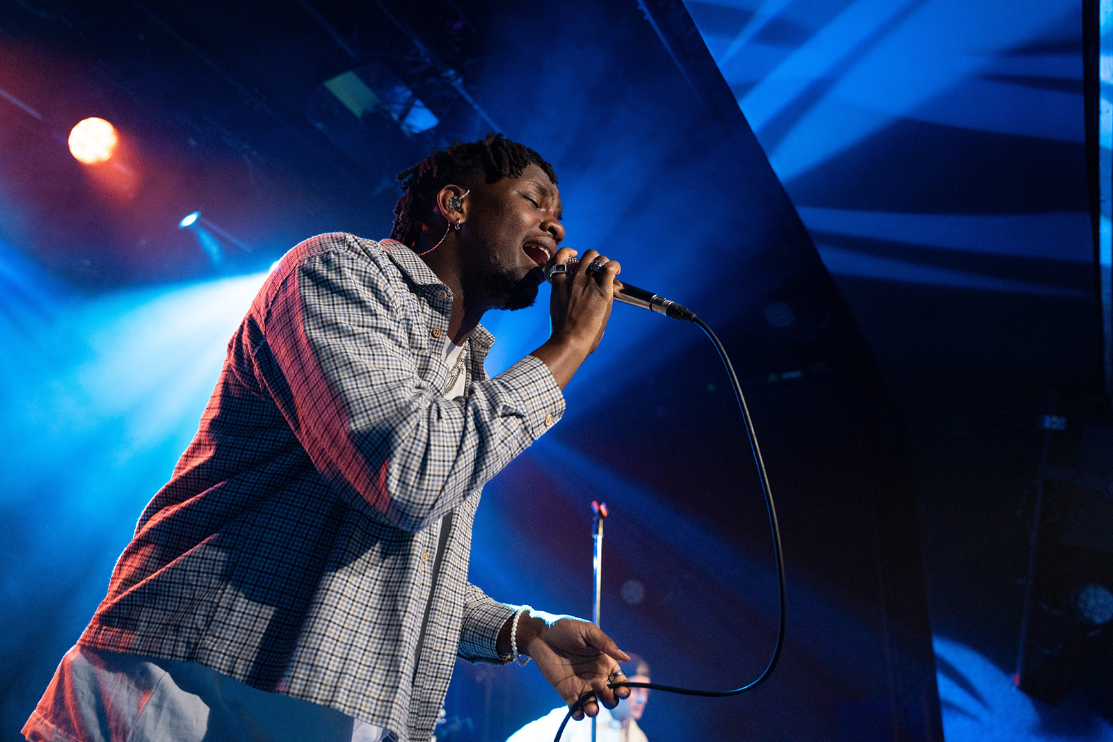 Artiste sur scène dans un halo de lumière agressive